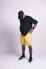 Short de baño amarillo liso con cintura elástica, bolsillos laterales y trasero con velcro, suspensor interno y etiqueta en el frente.