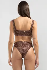 Bombacha de bikini marrón con estampado animal print, cobertura media y detalle de cinturón con dije de tigre.