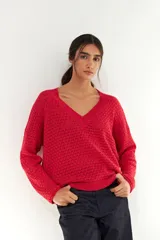 Sweater de punto con textura tipo esterilla, color rojo, con escote en V y mangas largas con puños acanalados.