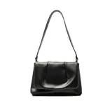 Cartera de hombro Korium modelo Nakia, color negro, con diseño estructurado y solapa frontal con detalle fruncido.