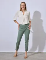 Pantalón de vestir verde esmeralda, de corte recto, con bolsillos laterales y traseros.