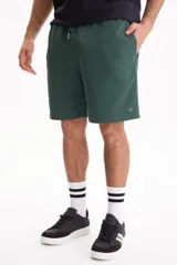 Bermuda deportiva sin friza color negro, con cintura elastizada y cordón ajustable. Corte semi baggy y suelto.