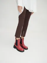 Botas estilo Chelsea de cuero vacuno rojo con grabado texturado tipo paisley, elásticos laterales negros y suela gruesa con taco de 5,5 cm.