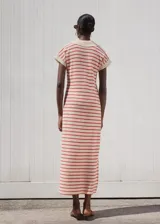 Vestido largo de punto fino con diseño a rayas horizontales rojas sobre fondo beige, de corte recto, manga corta y cuello polo en V.