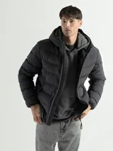 Campera de nylon capitoneada color negro con capucha y cierre frontal.