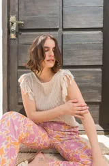 Musculosa tejida color violeta con diseño calado y flecos en los hombros.