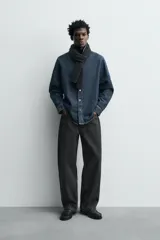 Camisa de corte relajado confeccionada en denim de algodón, con cuello solapa, manga larga con puños abotonados y cierre frontal de botones.