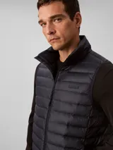 Chaleco acolchado tipo puffer de Calvin Klein, con cuello alto, cierre frontal con cremallera y diseño sin mangas.