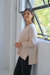 Sweater de punto en color crudo, con escote en V, mangas tres cuartos con puños acanalados y diseño holgado.