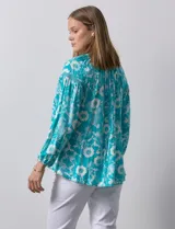 Blusa de gasa estampada marca Zac & Rachel. Tiene cuello a la base, escote en V con apertura y botones. Las mangas son 3/4 con frunce. Tiene detalle de crochet en hombros y delantera.