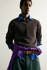 Jersey de punto tejido en hilatura de algodón con cuello en pico y manga larga, de corte regular fit y acabados en rib.