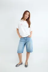 Bermuda de denim color blanco off-white, de tiro alto y corte recto y holgado, con bolsillos laterales y traseros.