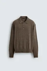 Polo de punto con cuello solapa y cierre frontal de tres botones. Presenta un diseño de manga larga con acabado en rib en puños y cintura, en un tono marrón jaspeado.