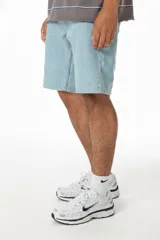 Bermuda de jean celeste, corte recto, largo hasta la rodilla, con costuras contrastadas, parche trasero de ecocuero con logo y confeccionada en Uruguay.