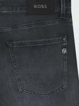 Jean de corte regular fit en color gris oscuro con efecto lavado, confeccionado en denim de alta calidad con cierre de botón y cremallera.