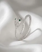 Anillo de plata 925 con diseño envolvente de serpiente, cubierto de circonias brillantes y ojos en color verde esmeralda.