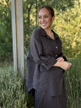 Camisa negra de manga larga con cuello clásico y cierre frontal con botones.