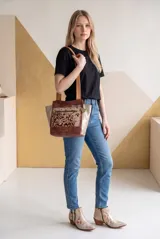 Cartera de cuero de la marca Carolina De Cunto, modelo Nia de la línea Ottenta Basic. Presenta diseño combinado en tonos marrón y tostado con detalles en pelo natural con estampado animal print, bolsillos con cierre exterior e interior, porta llaves y doble asa de hombro.