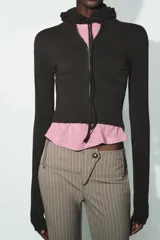 Sudadera cropped de punto con cierre frontal de cremallera metálica, capucha ajustable con cordones y mangas largas con puños en rib.