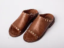 Sandalias de cuero color marrón con detalles de tachas doradas.