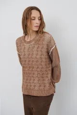 Buzo reversible de tejido de punto con diseño de trenzas, cuello redondo y mangas largas. Presenta una combinación de colores en contraste, con un lado en violeta y el otro en marrón oscuro.