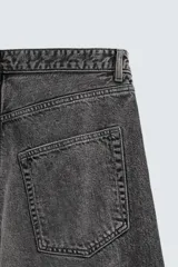 Jeans de denim de algodón, color azul oscuro con efecto lavado. Presentan un corte muy holgado (baggy fit) en toda la pierna y tiro medio. Tienen cinco bolsillos y cierre frontal con cremallera y botón.