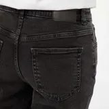 Pantalón jean de corte mom color negro gastado, tiro alto y largo al tobillo.