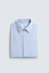 Camisa de corte slim fit confeccionada en tejido de algodón, con cuello italiano, manga larga con puños abotonados y cierre frontal de botones.