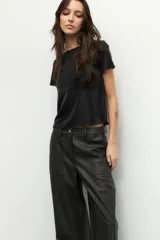 Pantalón ancho de símil cuero color negro, con grandes bolsillos laterales y traseros.