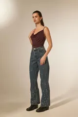 Pantalón jean azul de corte recto y calce alto, con bolsillos y detalles de strass.