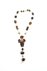 Collar largo con cuentas de piedras en tonos marrones y negros, eslabones dorados y dije central en forma de flor esmaltada con caireles colgantes.