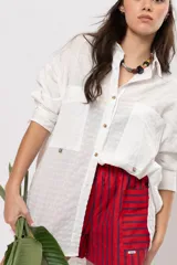 Camisa amplia blanca con bolsillos frontales gigantes y cierre frontal con botones.