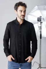 Camisa negra de piqué, corte clásico, con cuello abotonado y bolsillo en el pecho.