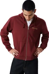 Buzo con cierre frontal completo y capucha, color bordó, con logo bordado en el pecho y bolsillos tipo canguro.