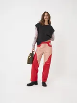 Pantalón de cuero a dos colores con cortes curvos, color rosa y rojo.