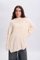 Sweater de punto liso en color crudo, de diseño oversize con cuello redondo acanalado y mangas amplias.
