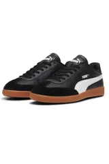 Championes Puma modelo 9T, color negro con franja lateral blanca y suela de goma marrón estilo gum, con puntera de gamuza.