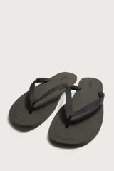 Sandalia de goma color negro, de diseño plano y tiras delgadas en el empeine estilo ojota.