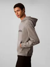 Buzo con capucha de corte regular, confeccionado en mezcla de algodón regenerado y poliéster reprocesado. Presenta diseño de manga larga, puños y cintura acanalados, bolsillo tipo canguro y logo de la marca estampado en el pecho.