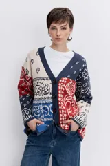 Cardigan de punto con diseño jacquard estilo patchwork en tonos azul, rojo y crema. Presenta un estampado tipo bandana, cuello en V, cierre frontal con botones y mangas largas.