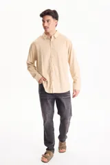 Camisa de lino de manga larga, color beige, con cuello clásico y cierre frontal de botones.