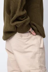 Pantalón cargo color beige, con bolsillos laterales tipo cargo con solapa y cierre de botón, corte recto y ajuste cómodo.