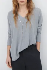 Sweater de tejido de punto color beige, con escote en V y mangas largas. Presenta un diseño básico y versátil de corte recto.