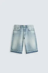 Bermuda de denim de algodón, color celeste claro con efecto lavado. Diseño de cinco bolsillos, corte ancho (baggy fit) y bajo con acabado irregular.