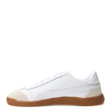 Championes urbanos Puma modelo Club 5V5 Lux, de color blanco con detalles en beige en la puntera y suela de goma color caramelo. Presentan el logo de la marca en dorado en el lateral y cuentan con cierre de cordones.
