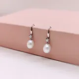 Caravanas de plata 925 con diseño colgante, compuestas por una perla de río en forma de gota y una circonia brillante en la parte superior.