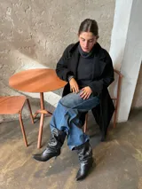 Botas de cuero negro de caña media con diseño fruncido tipo slouchy, punta fina y taco bajo.
