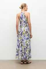 Maxi vestido largo de tirantes con cuello en V, corte fluido y estampado floral en tonos azules y verdes sobre base blanca.