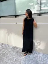 Vestido largo sin mangas, color marrón oscuro o ciruela, de tejido acanalado (morley) con caída amplia.