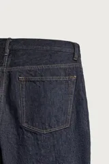 Pantalón jeans straight fit de tiro bajo, confeccionado en denim de algodón oscuro sin lavados, con diseño de pierna recta, cinco bolsillos y cierre frontal de botonadura.